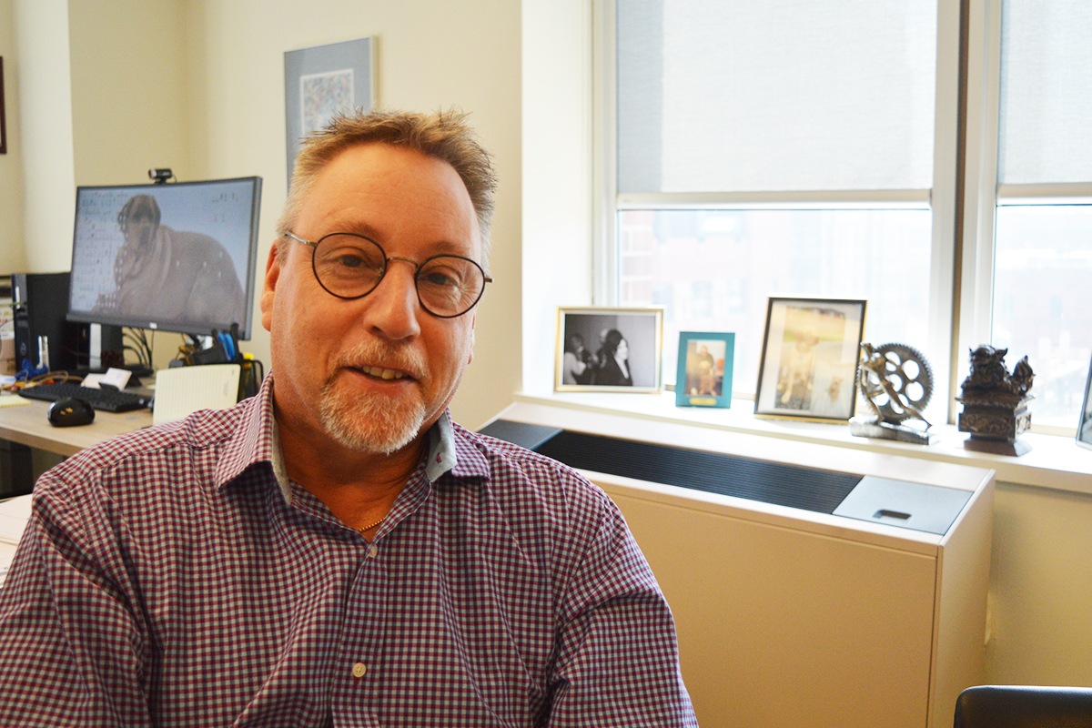Cory Ross sits in office at George Brown College